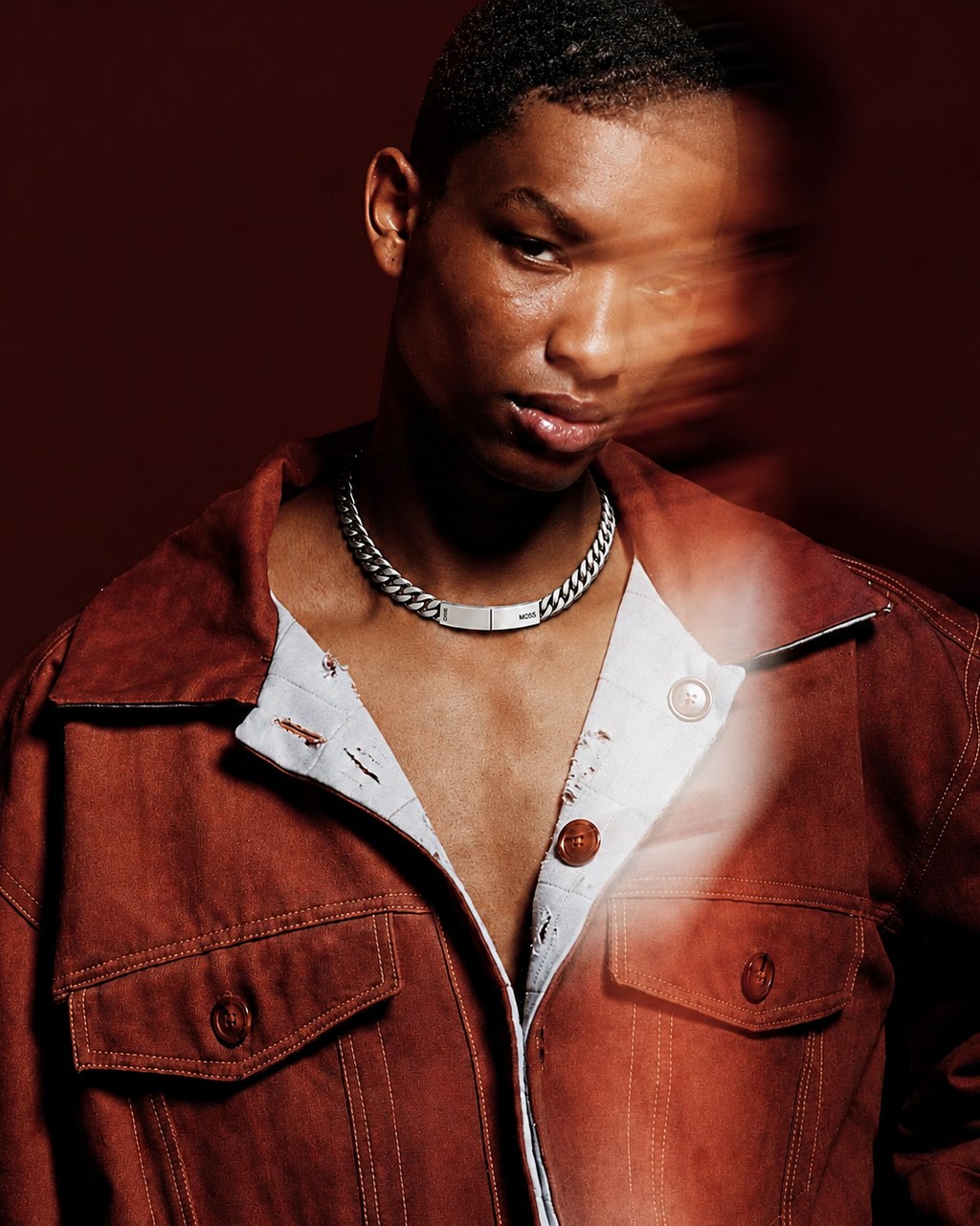 Model in a red jacket wearing a Cuban chain with a box clasp